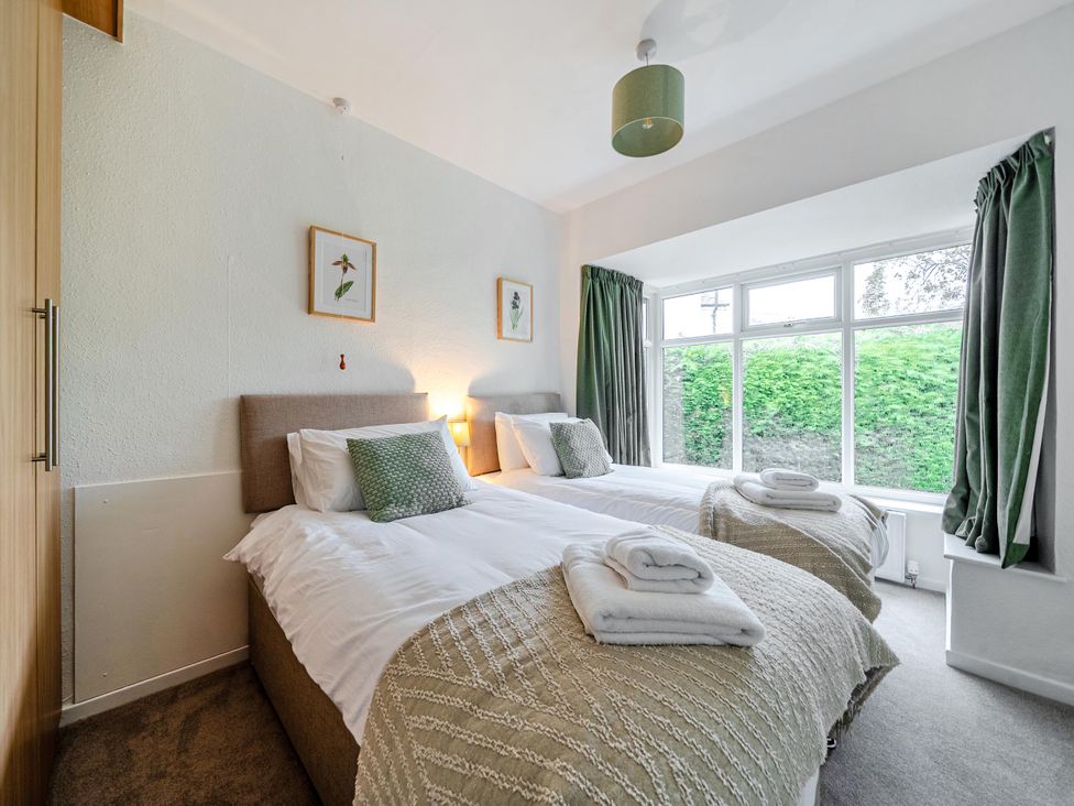 A bedroom with two single beds and a window at Waltergarth in Horton-In-Ribblesdale