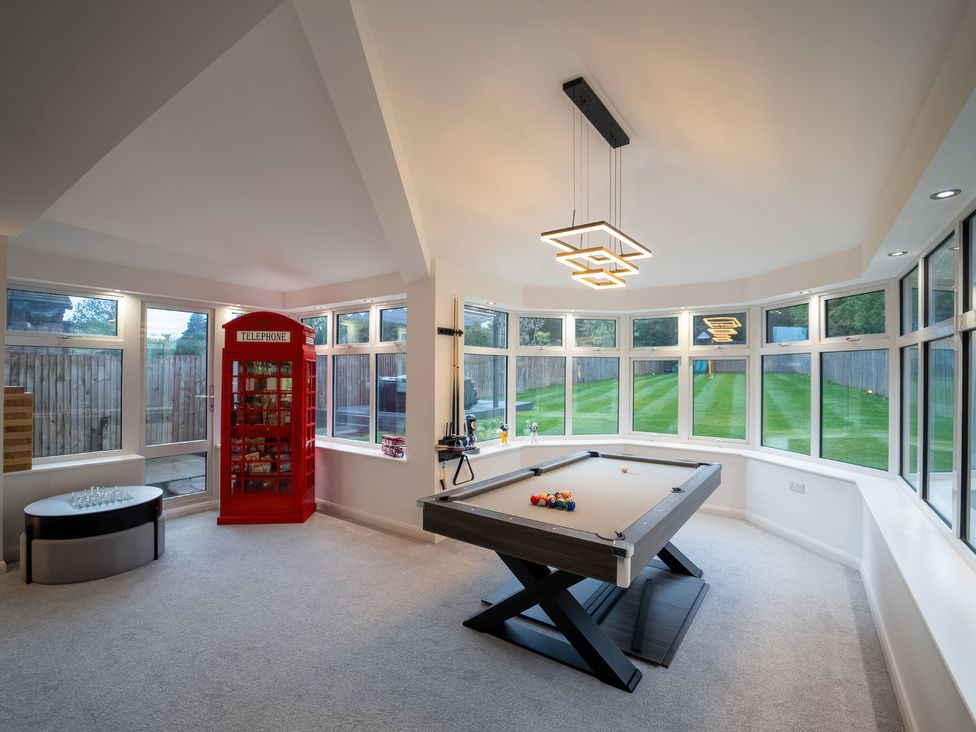 A snug room with a pool table and large windows at 29 Batchworth Lane in Northwood, Hertfordshire