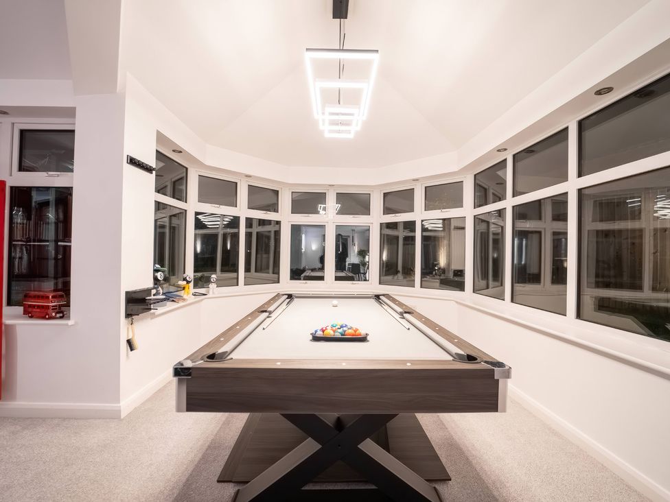 A game room with a pool table and large windows at 29 Batchworth Lane Northwood, Hertfordshire