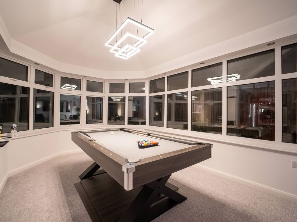 A game room with a billiard table and large windows at 29 Batchworth Lane Northwood, Hertfordshire