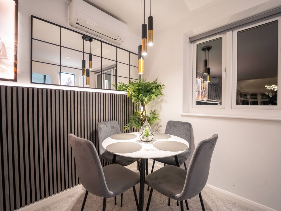 A dining room with a round table and chairs at 29 Batchworth Lane Northwood Hertfordshire