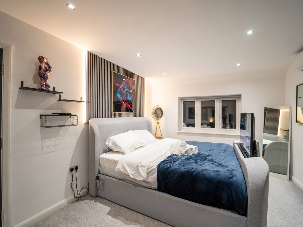 A bedroom with a bed and shelves at 29 Batchworth Lane Northwood, Hertfordshire