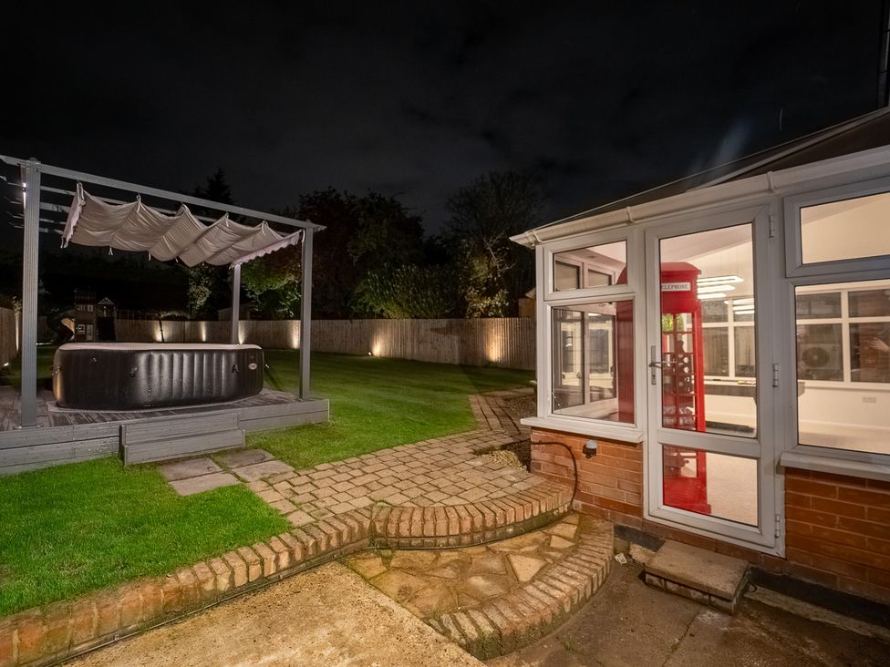 A garden with a hot tub and a telephone box at 29 Batchworth Lane, Northwood, Hertfordshire