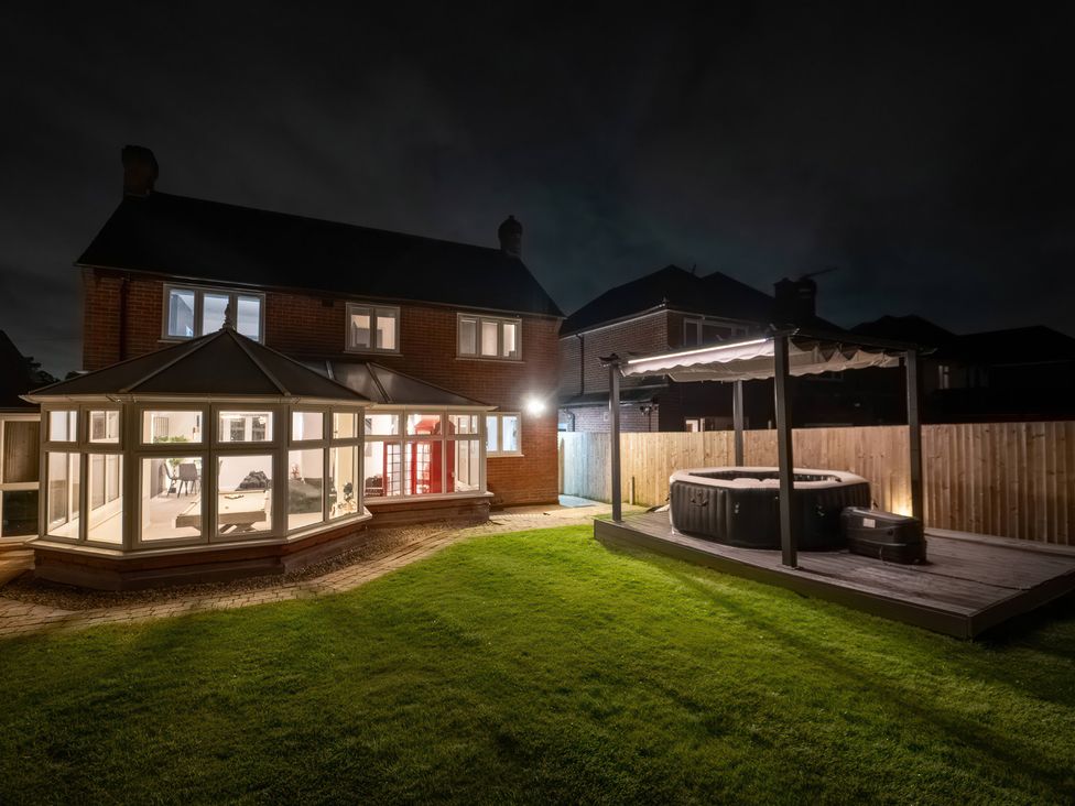 A garden with a hot tub and a conservatory at 29 Batchworth Lane Northwood Hertfordshire
