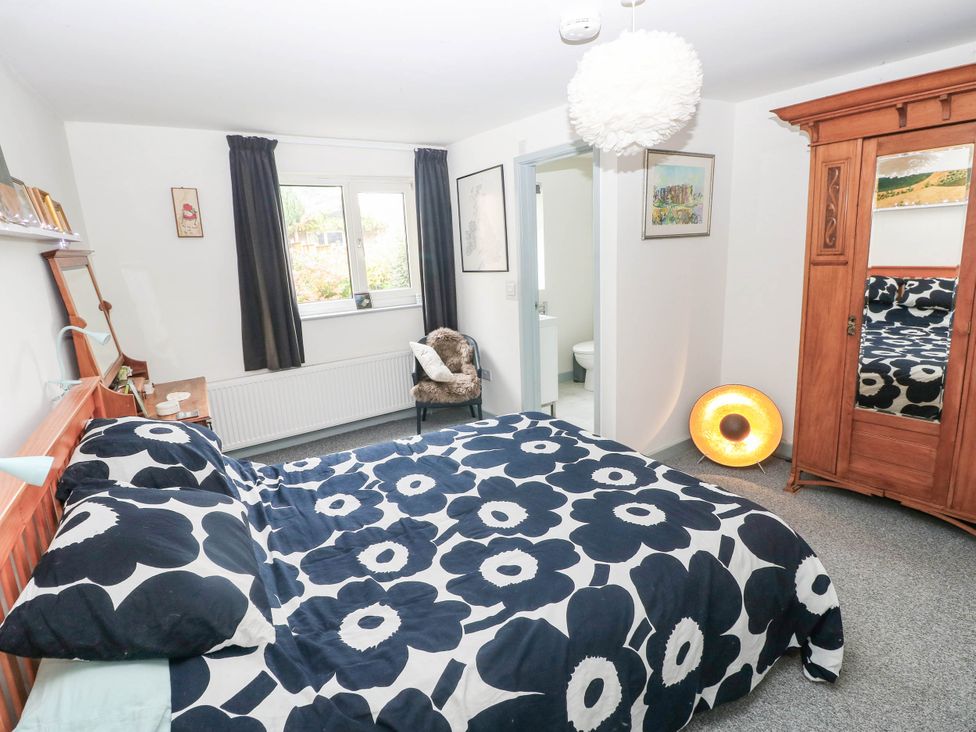 A bedroom with a bed and wardrobe at 11 Church Street in Narberth