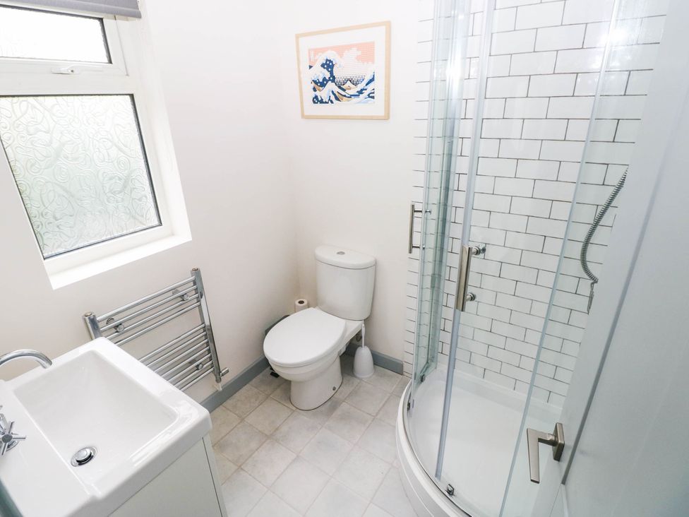 A bathroom with a shower, toilet, and sink at 11 Church Street, Narberth