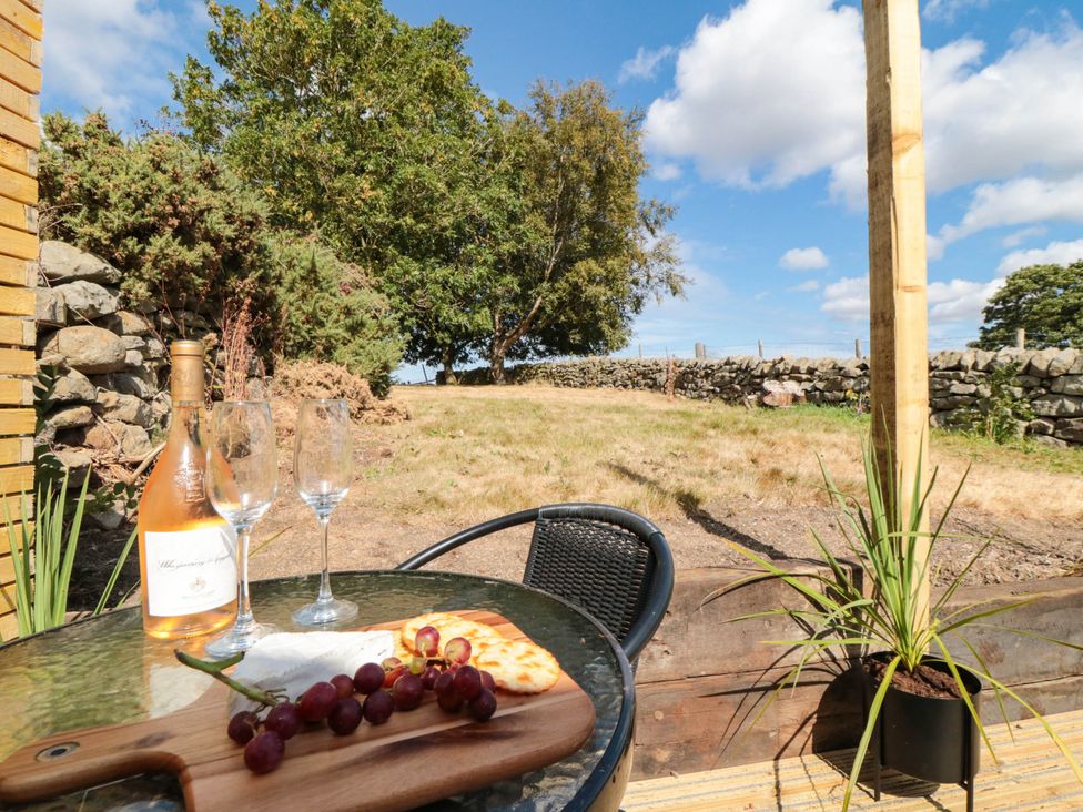 An outdoor area with wine glasses and a bottle at Windy Ridge Lodge in Egton