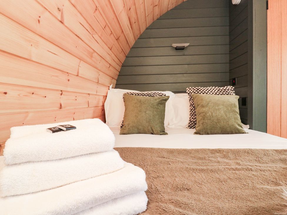 A bedroom with a bed and pillows at Windy Ridge Lodge in Egton