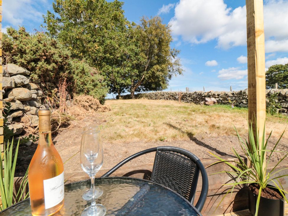 A table with a bottle and glass on a patio at Windy Ridge Lodge Egton
