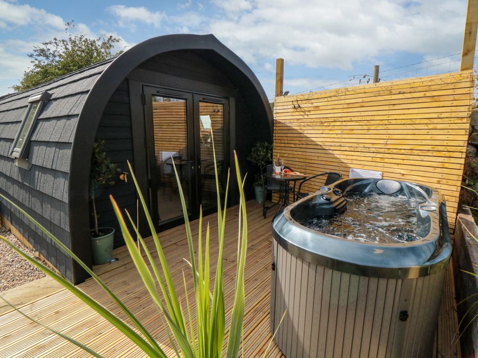 An outdoor area with a hot tub and seating at Windy Ridge Lodge in Egton