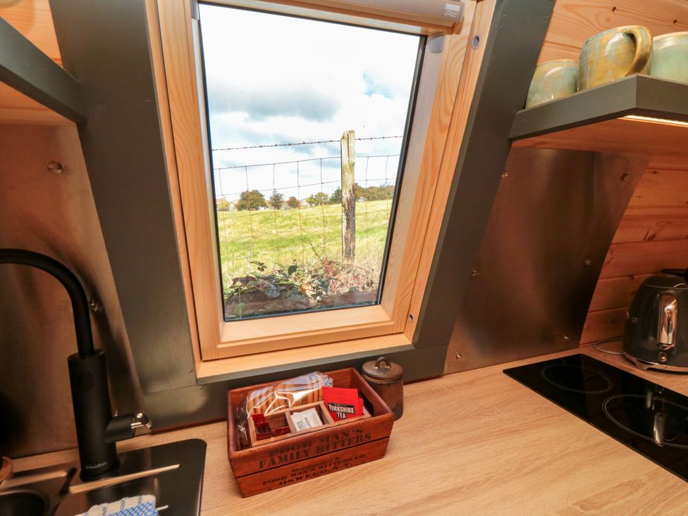 A kitchen view with a window showing a field at Windy Ridge Lodge in Egton