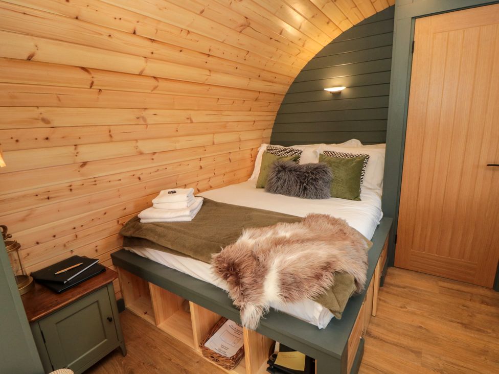 A bedroom with a bed and wooden decor at Windy Ridge Lodge Egton