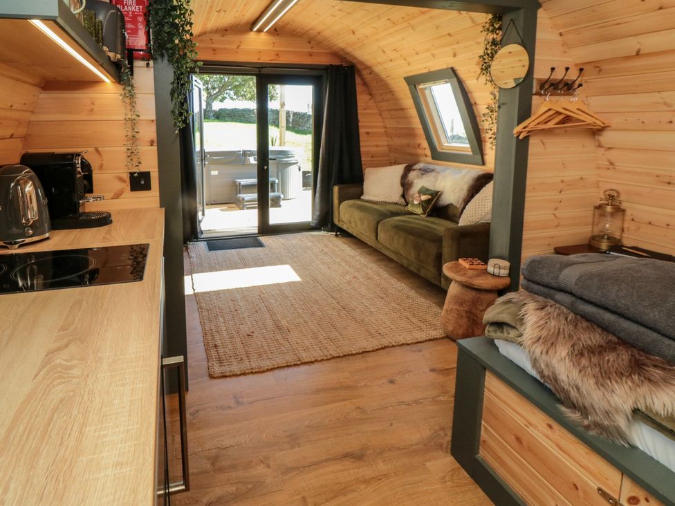 A living room with a sofa and kitchenette at Windy Ridge Lodge in Egton