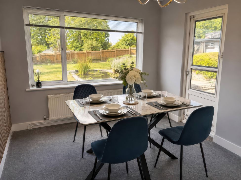A dining room with a table set for meals at 35 Vivian Gardens Watford