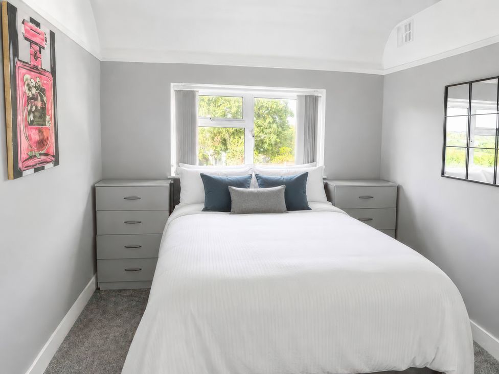 A bedroom with a bed and dressers at 35 Vivian Gardens Watford