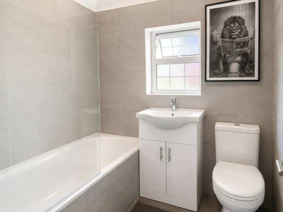 A bathroom with a bathtub, sink, and toilet at 35 Vivian Gardens Watford