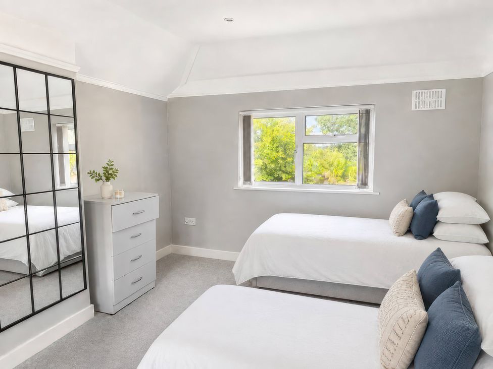 A bedroom with two beds and a dresser at 35 Vivian Gardens Watford