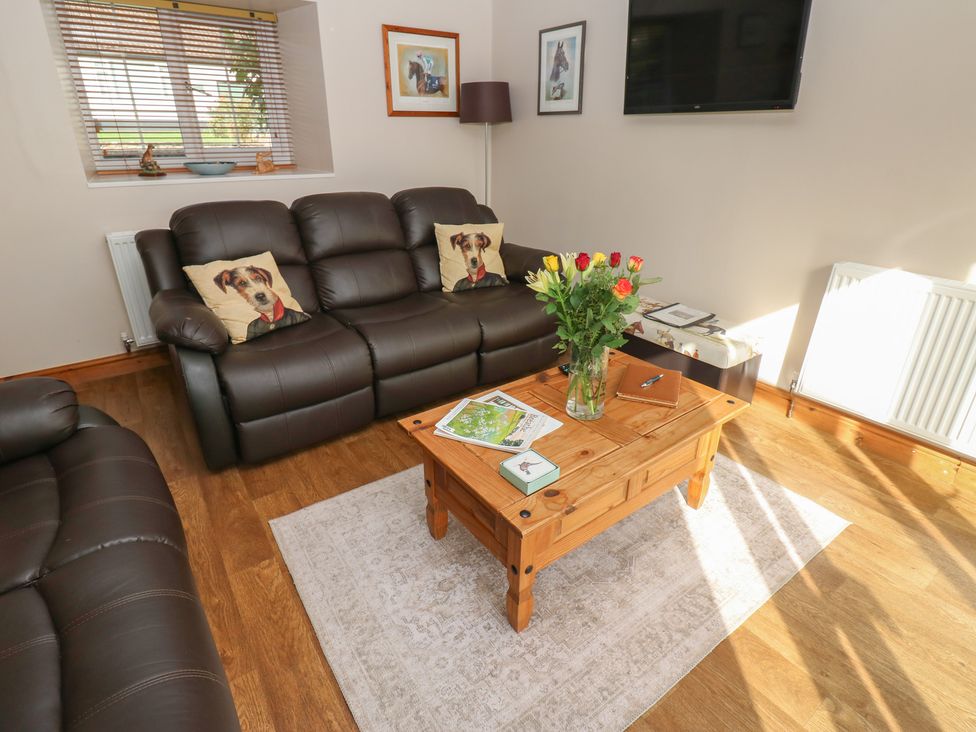 A living room with a sofa and coffee table at Millstone Cottage in Ripon