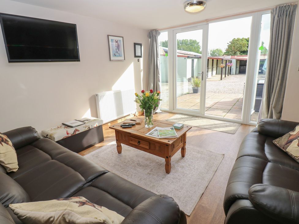 A living room with a coffee table and television at Millstone Cottage in Ripon