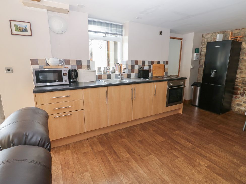 A kitchen with appliances and counter space at Millstone Cottage in Ripon