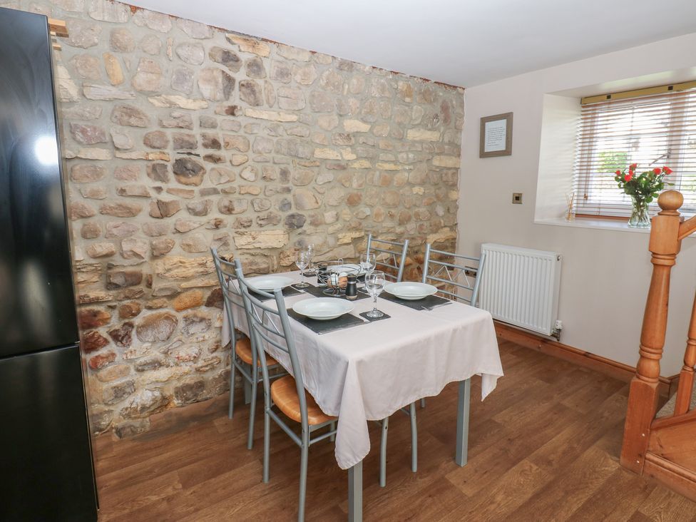 A dining room with a table and chairs at Millstone Cottage Ripon