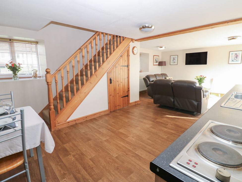 A living room with a sofa and staircase at Millstone Cottage Ripon