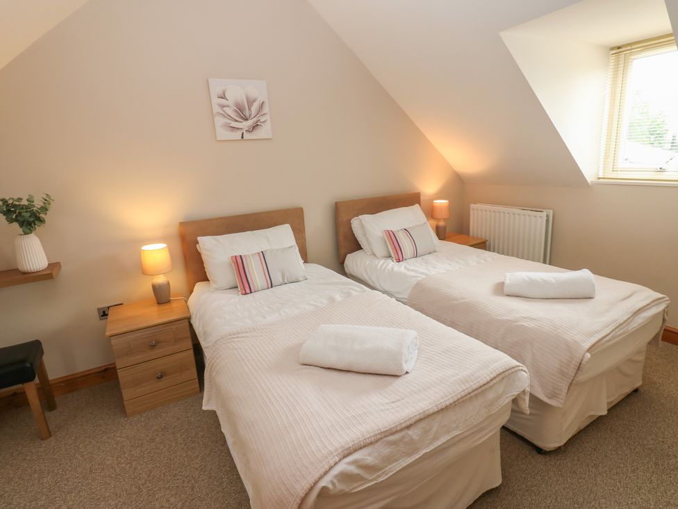 A bedroom with twin beds and nightstands at Millstone Cottage, Ripon