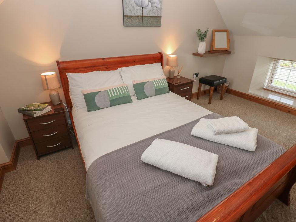 A bedroom with a bed and bedside table at Millstone Cottage in Ripon