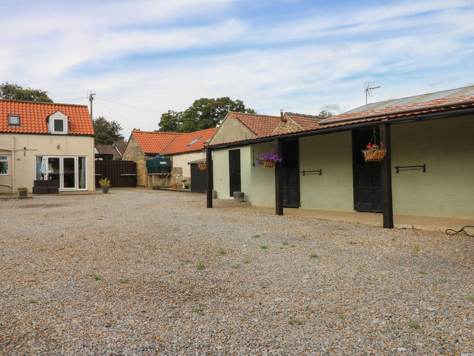 An outdoor area with a house and stable at Millstone Cottage in Ripon