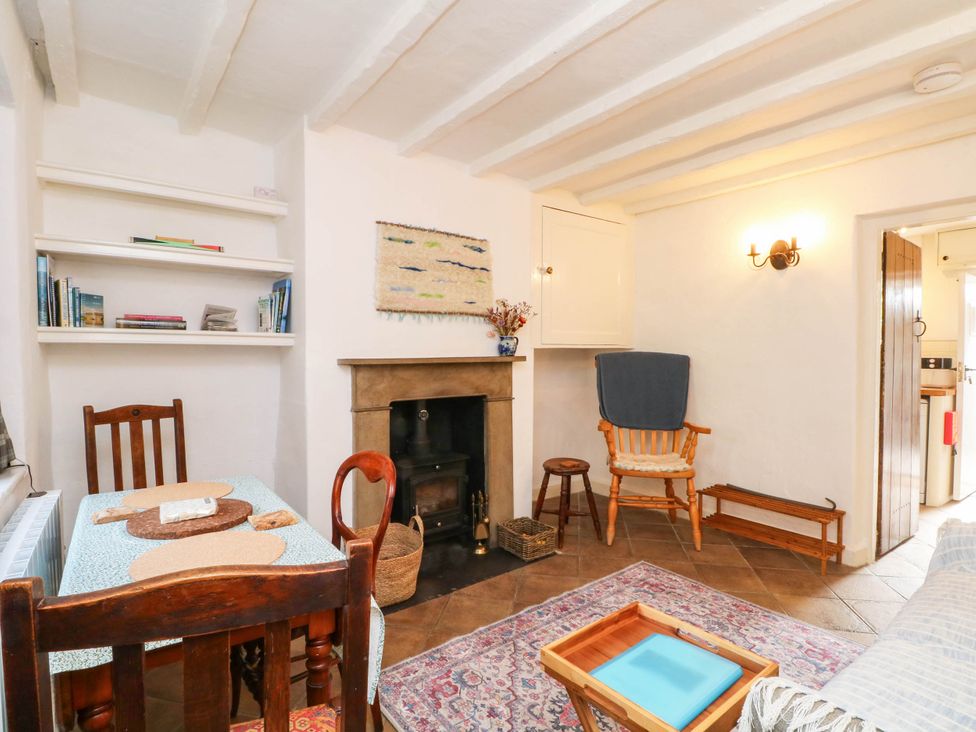 A living room with a dining table and a fireplace at 73 Ravensdale Cottages, Cressbrook near Litton, Derbyshire