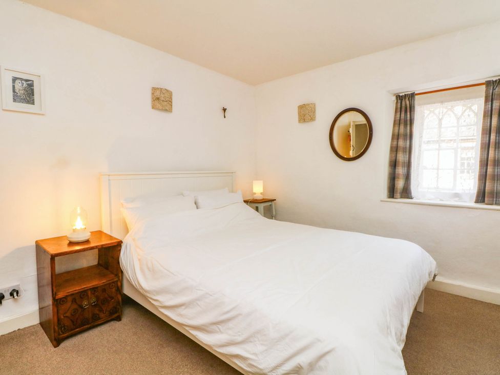 A bedroom with a bed and lamp at 73 Ravensdale Cottages in Cressbrook near Litton, Derbyshire