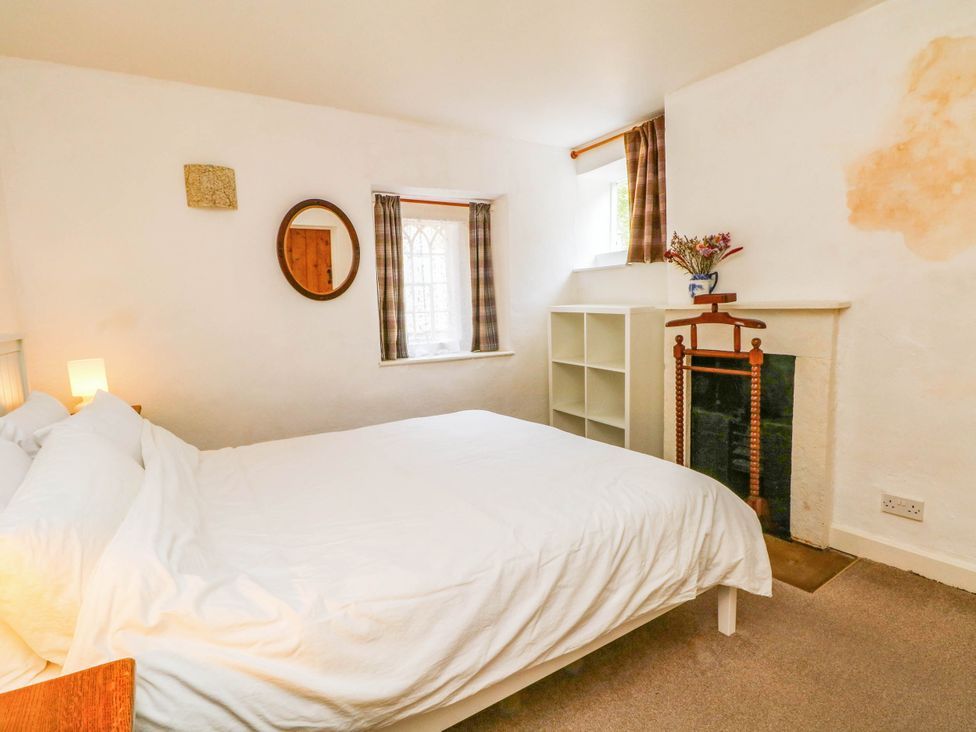 A bedroom with a bed and shelves at 73 Ravensdale Cottages Cressbrook near Litton Derbyshire