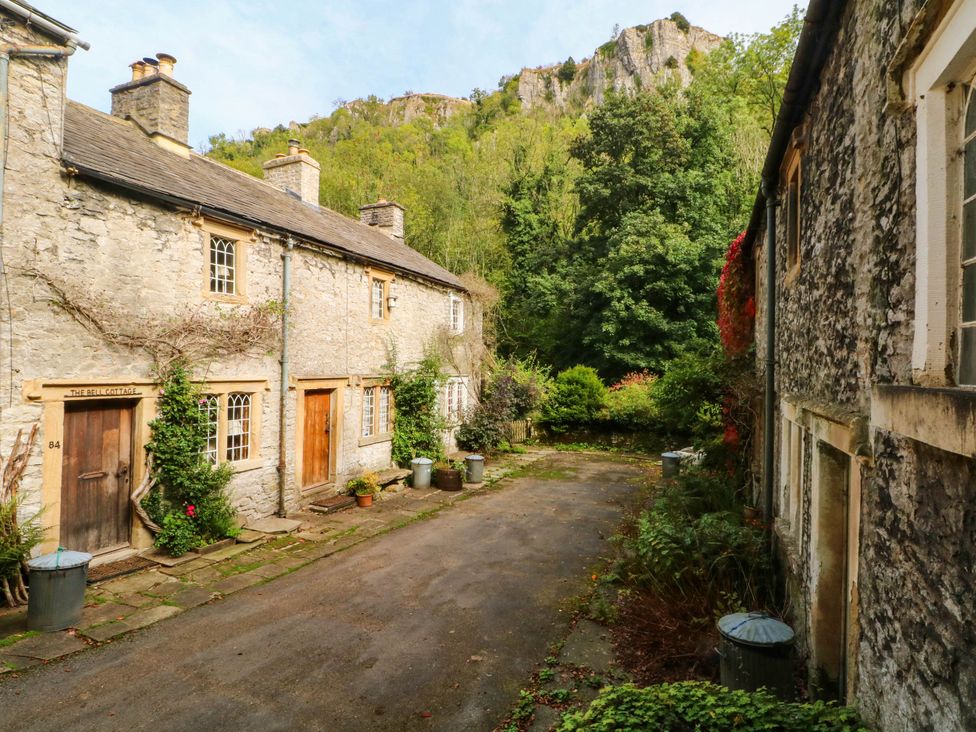 An outdoor area with stone cottages and a pathway at 73 Ravensdale Cottages, Cressbrook near Litton, Derbyshire