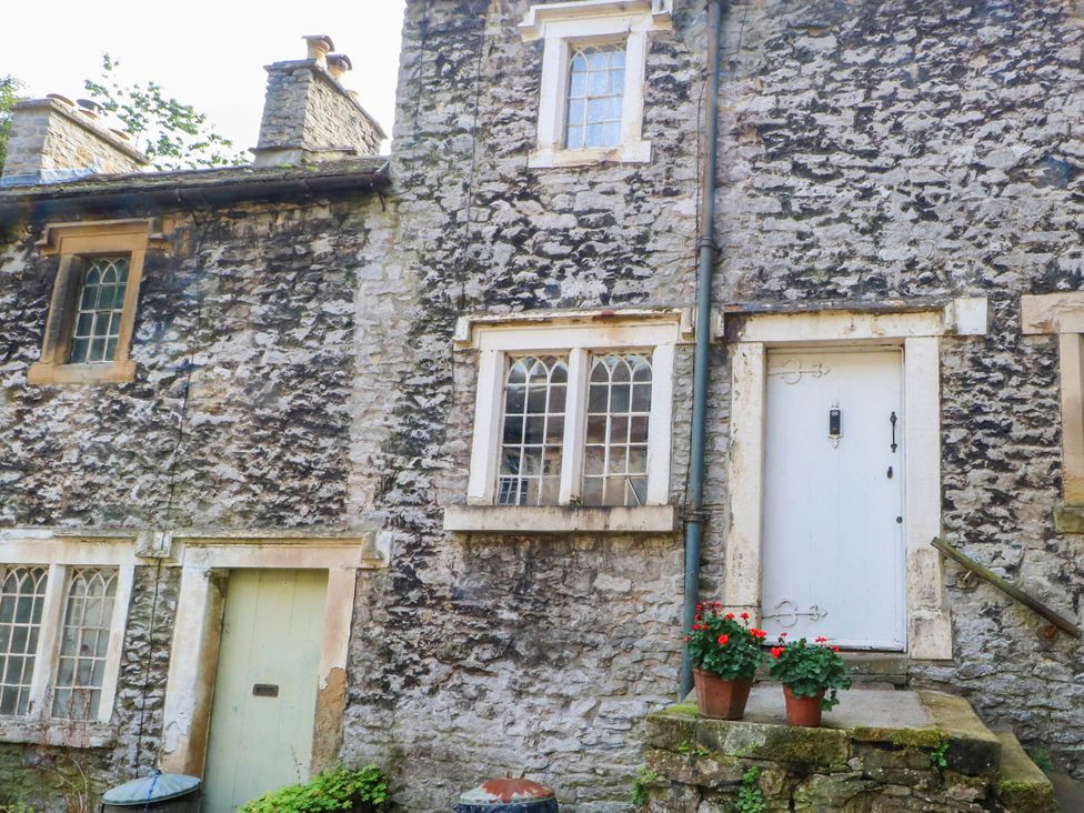 An exterior view of a stone cottage with a door and windows at 73 Ravensdale Cottages Cressbrook near Litton, Derbyshire