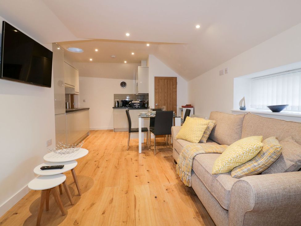 A living room with a kitchen and dining area at Fishermans Loft in Mevagissey