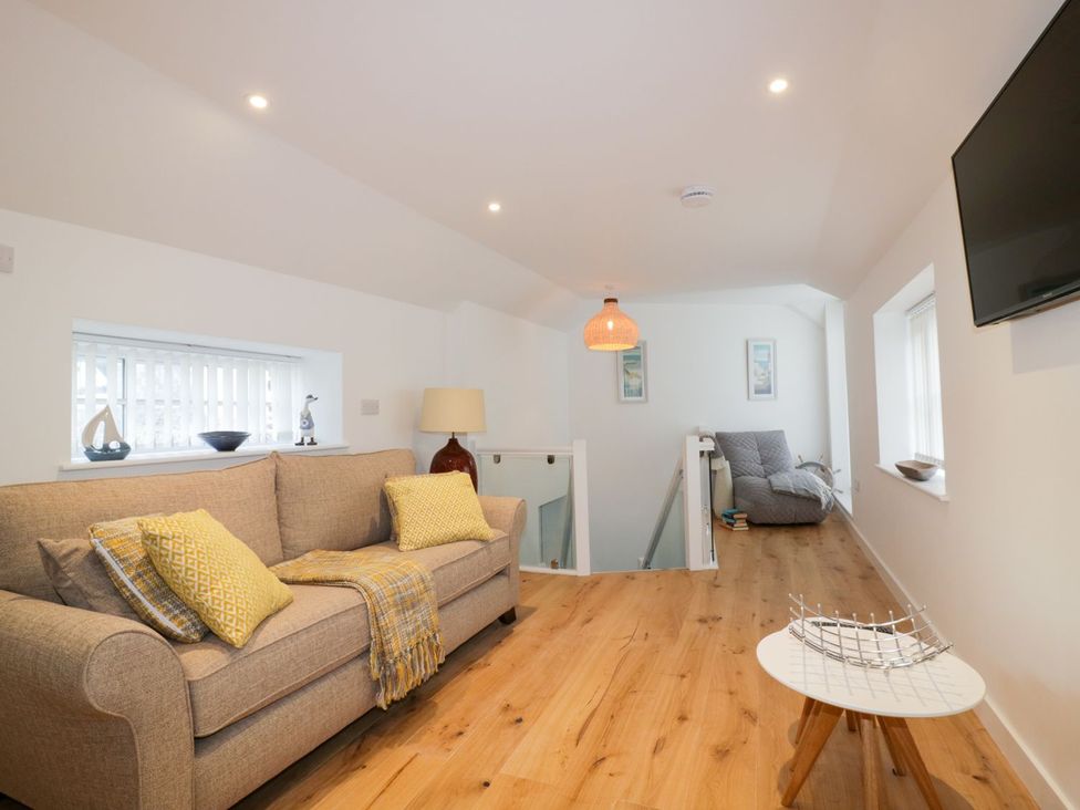 A living room with a sofa and coffee table at Fishermans Loft in Mevagissey
