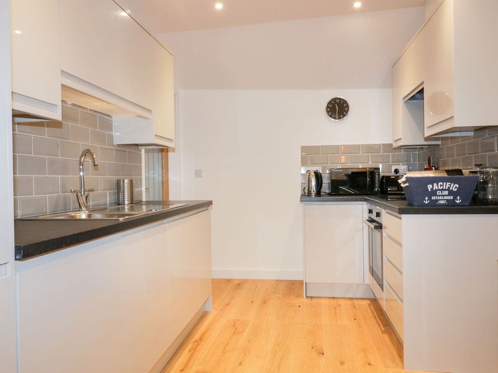 A kitchen with cabinets and appliances at Fishermans Loft in Mevagissey
