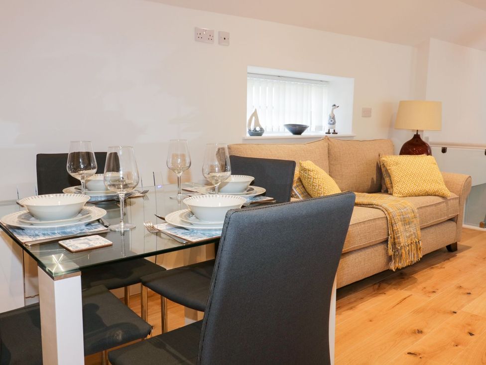 A living room with a dining table and sofa at Fishermans Loft in Mevagissey