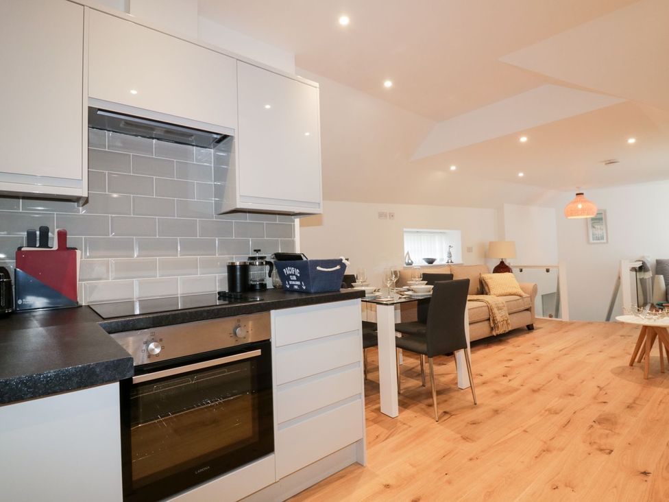 A kitchen with appliances and seating area at Fishermans Loft in Mevagissey