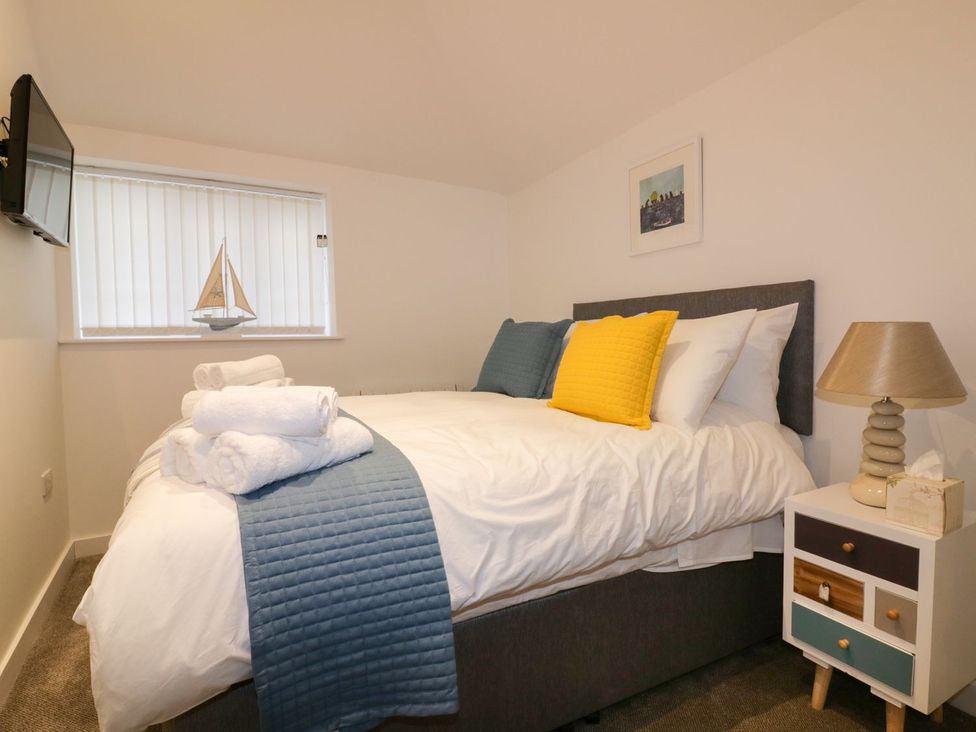 A bedroom with a bed and bedside table at Fishermans Loft in Mevagissey