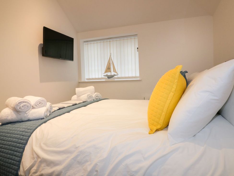 A bedroom with a bed and television at Fishermans Loft in Mevagissey