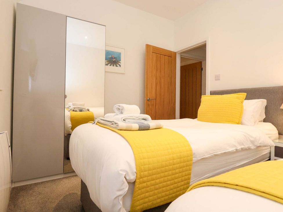 A bedroom with a bed and wardrobe at Fishermans Loft in Mevagissey