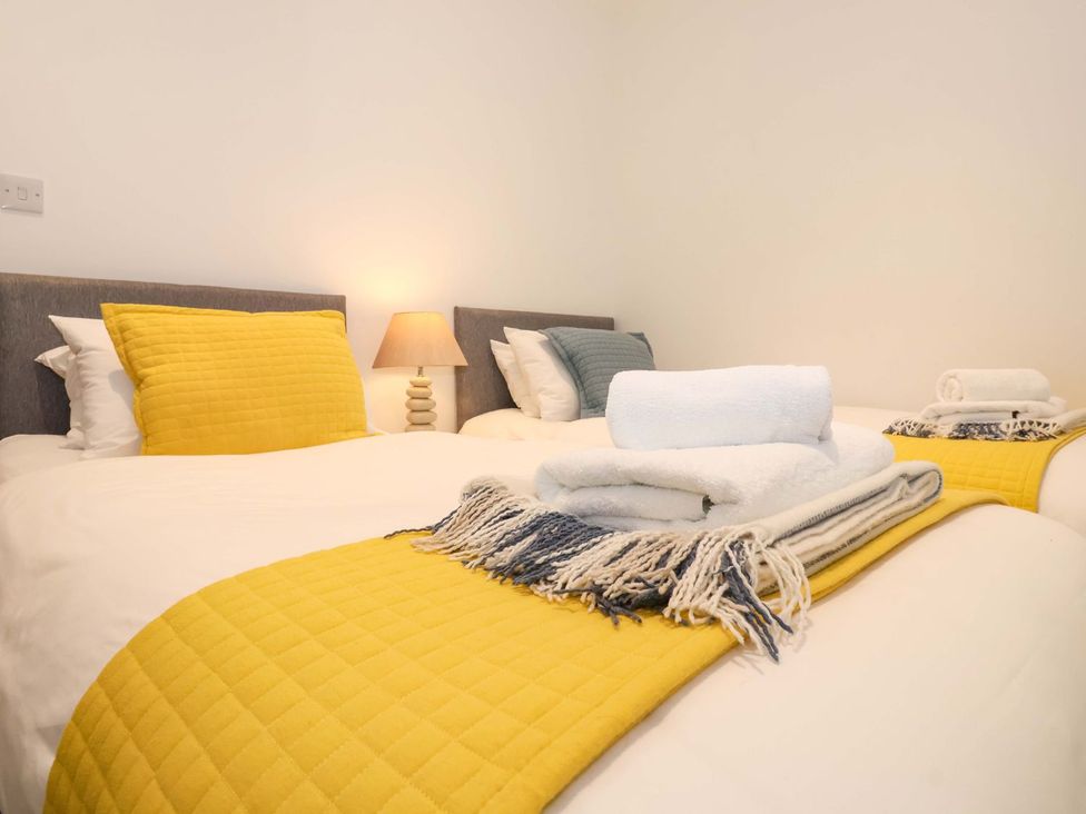 A bedroom with two beds and folded towels at Fishermans Loft in Mevagissey