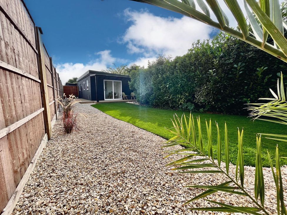 A garden with a gravel path and a building in Luxurious guest house in Yorkshire with parking, Hemingbrough, Yorkshire
