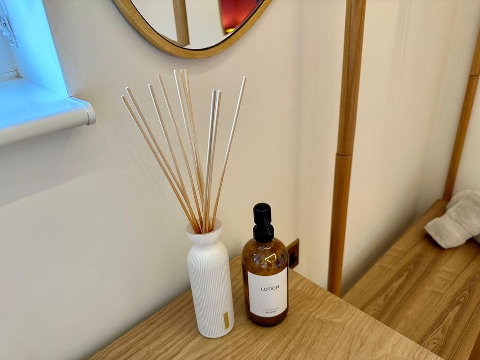 A reed diffuser and lotion bottle on a wooden table at Luxurious guest house in Yorkshire with parking, Hemingbrough, Yorkshire