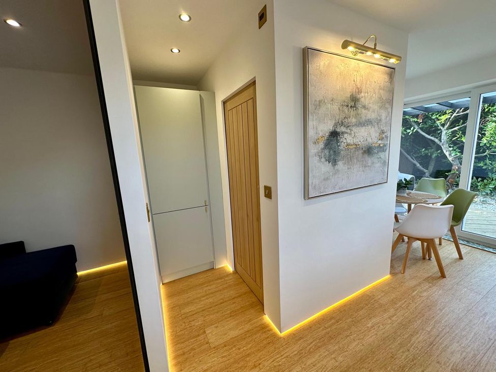 A hallway with a cabinet and wall light at Luxurious guest house in Yorkshire with parking, Hemingbrough, Yorkshire
