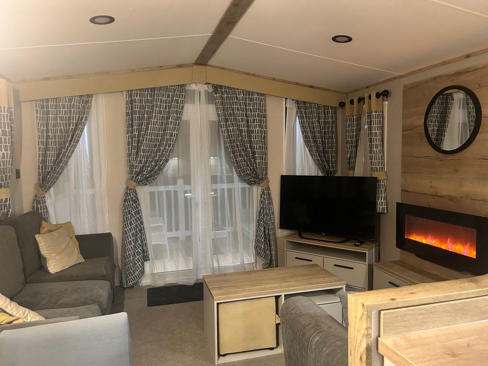 A living room with a sofa, TV, and electric fireplace at the property in 