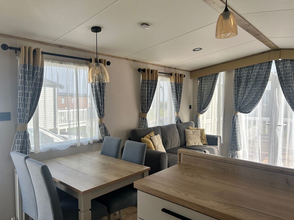 A living room with a table and chairs next to a sofa