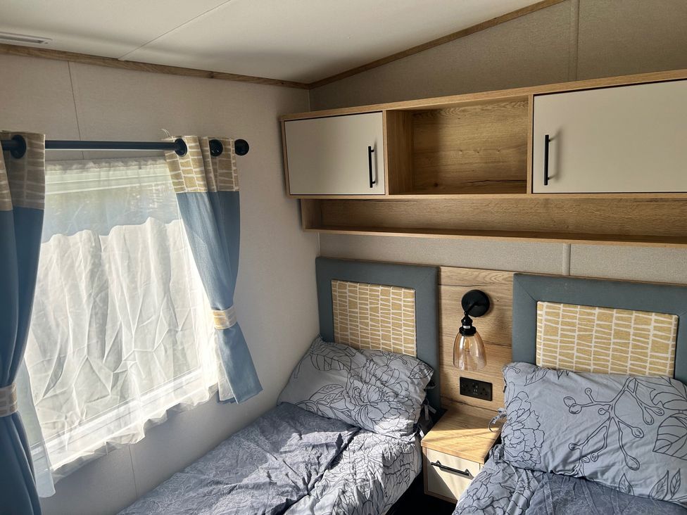 A bedroom with two beds and a shelf at a property