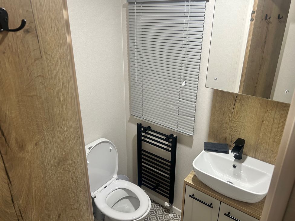 A bathroom with a toilet, sink, and mirror in a compact space